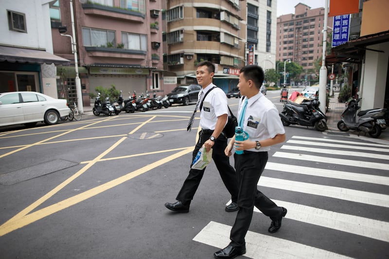 Un par de misioneros de tiempo completo cruzan la calle en Taiwán en 2025.