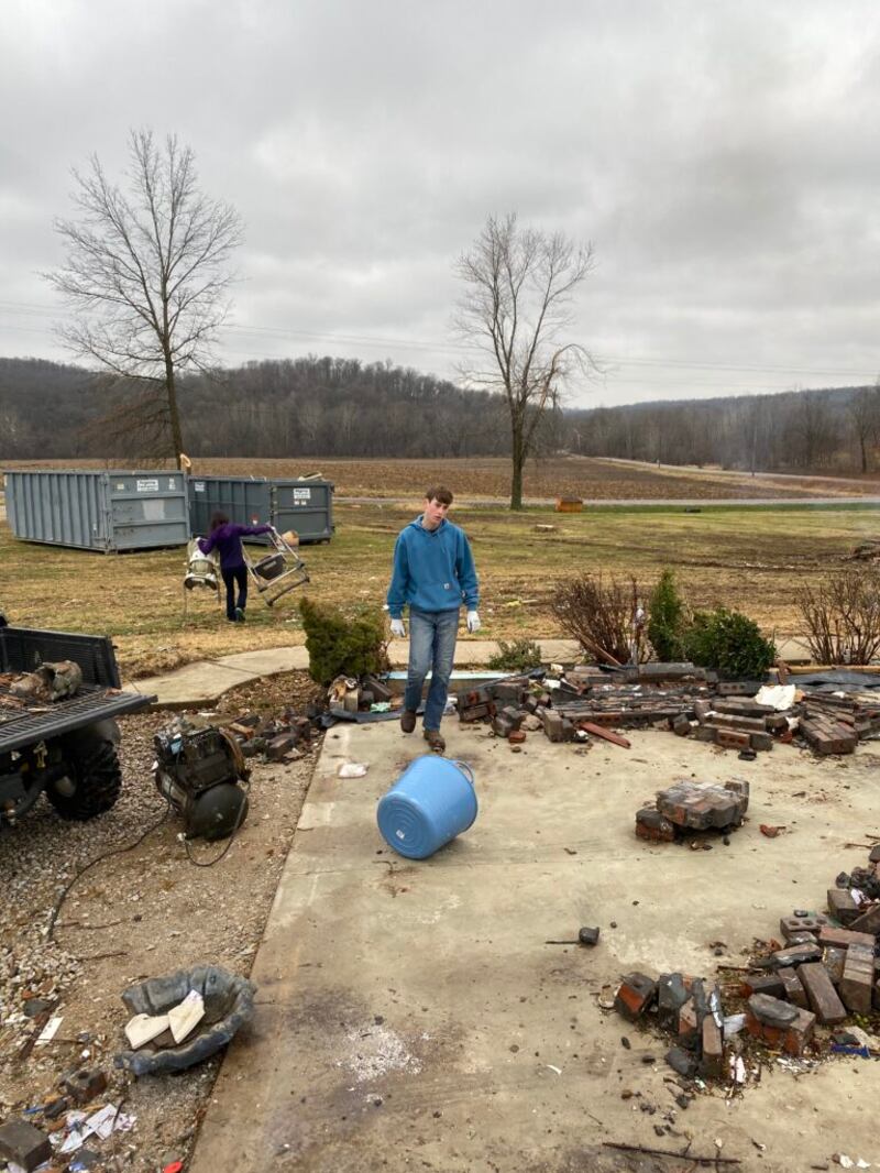 Tami Hale y Harrison Hoyt recogen ramas, palos y otros escombros de un pastizal alrededor de Defiance, Missouri. Los miembros de la Estaca Lake St. Louis, Missouri, pasaron el domingo, 19 de diciembre de 2021 limpiando los daños del tornado la semana anterior.