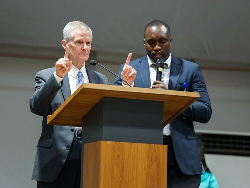 El élder David A. Bednar habla en el púlpito junto a un traductor durante un devocional en Kigali, Ruanda, el 17 de marzo de 2026.