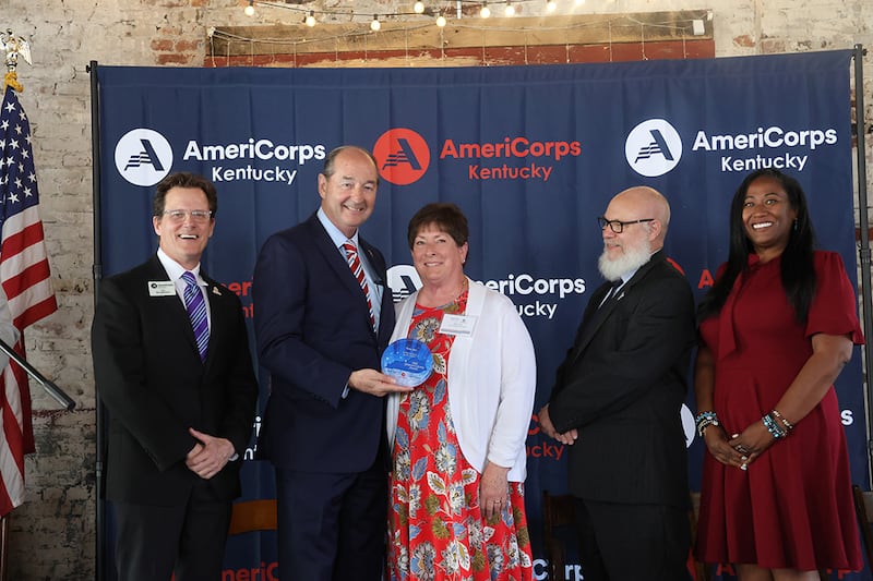 Terry Fiet, al centro, recibe el Premio Estatal al Servicio Voluntario de Personas Mayores de Rocky Adkins, asesor principal del gobernador Andy Beshear, y otros en Frankfort, Kentucky, el 25 de abril de 2025.