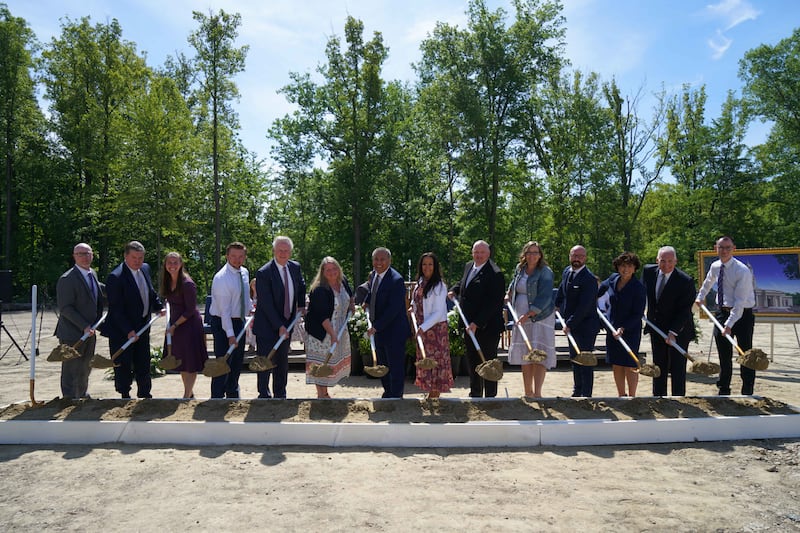 Leaders and members use shovels at temple groundbreaking.