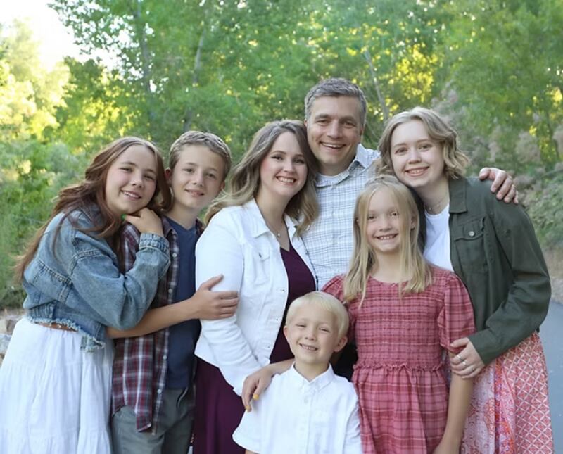 Traci Law — compositora del nuevo himno "Pequeño Niño en un Pesebre", al centro — sonríe para un retrato con su familia en Spanish Fork, Utah, 2021.