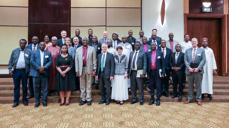 El élder David A. Bednar y la hermana Susan Bednar se toman una foto con unos 30 miembros del Consejo Interreligioso de Ruanda en Ruanda, el 16 de marzo de 2026.