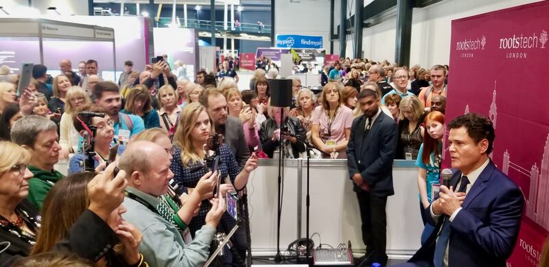 El animador santo de los últimos días, Donny Osmond (derecha), se reúne con los medios de comunicación en RootsTech Londres, el 26 de octubre de 2019, mientras una larga fila de participantes lo espera para conocerlo y saludarlo.