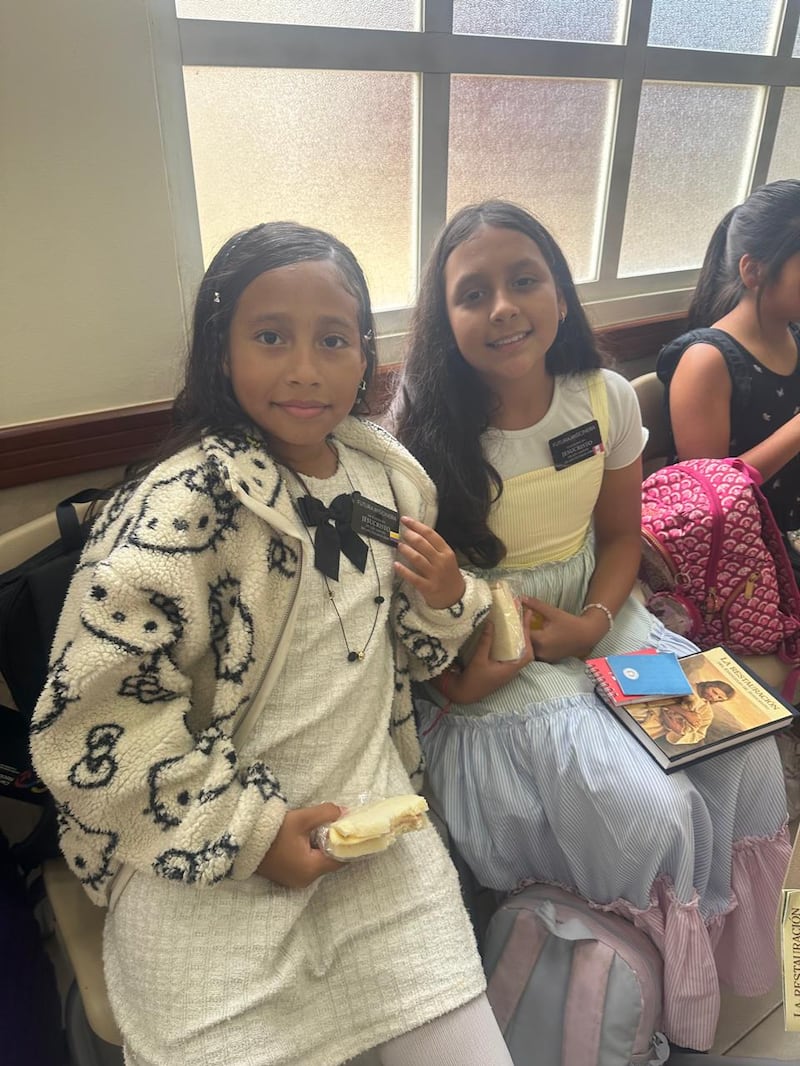Maite Luis, a la izquierda, y Lia Guiracocha Mendoza usan etiquetas de "futura misionera" y sonríen para una foto durante la actividad del centro de capacitación misional en miniatura de la Primaria de la Estaca Samborondón Ecuador, en Guayaquil, Ecuador, el 21 de febrero de 2026.