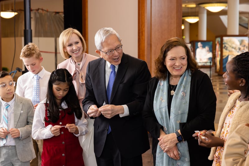 El élder Gerrit W. Gong, la hermana Susan Gong y la hermana Amy A. Wright abren galletas de la fortuna con los niños durante la grabación del Amigo a Amigo de mayo de 2026.