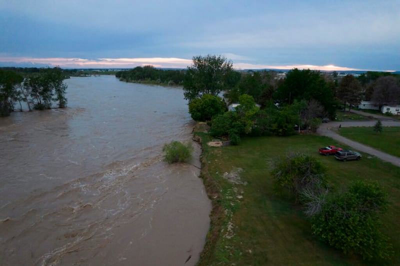 El rugiente río Yellowstone se ve desde el aire pasando sobre los árboles y cerca de las casas el martes, 14 de junio de 2022 en Billings, Montana.