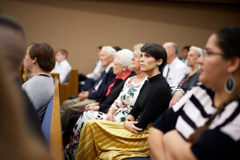 Church members seated in a Latter-day Saint chapel listen to a speaker.