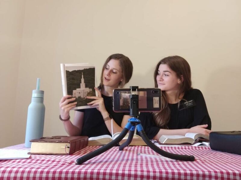 La hermana Lindsey Schmidt, a la izquierda, y la hermana Elise Winger, de la Misión Italia Milán, enseñan a un investigador mediante un teléfono inteligente en Bolonia, Italia, en mayo de 2020.