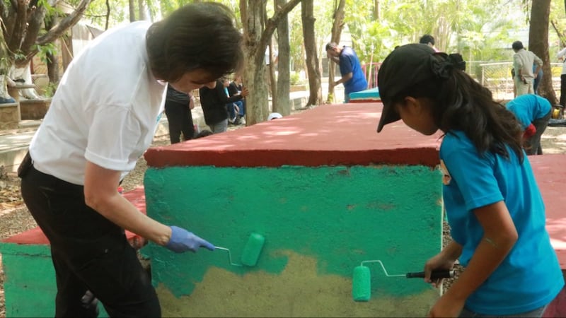 La presidenta Susan H. Porter ayuda a una niña a pintar partes de un parque público durante una actividad de servicio en Tuxtla Gutiérrez, Chiapas, México, en mayo de 2026.