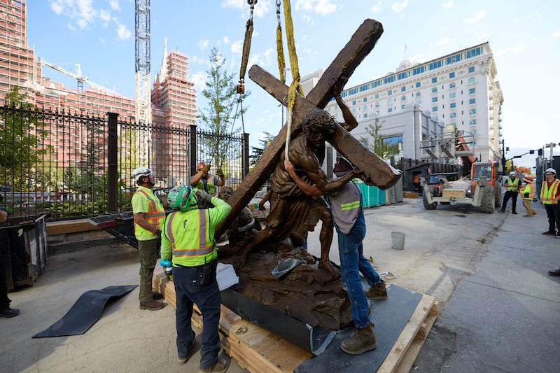 Los miembros del equipo instalan la estatua "Jesucristo llevando la cruz", creada por Michael Hall, al sur del Templo de Salt Lake el miércoles 17 de septiembre de 2025.
