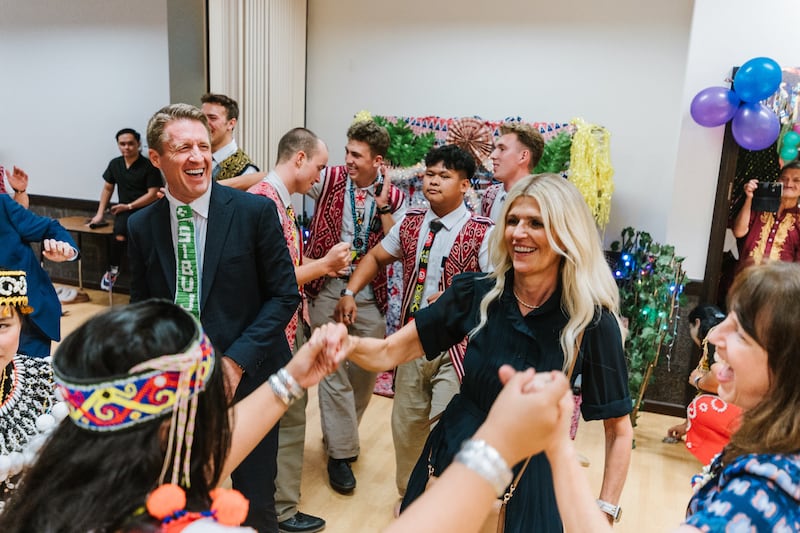 El presidente general de los Hombres Jóvenes, Timothy L. Farnes, a la izquierda, y su esposa, la hermana Linsey Farnes, interactúan con jóvenes durante un festival de cosecha Gawai en Sibu, Malasia, como parte de una asignación ministerial a países de Asia, del 21 al 31 de mayo de 2026.