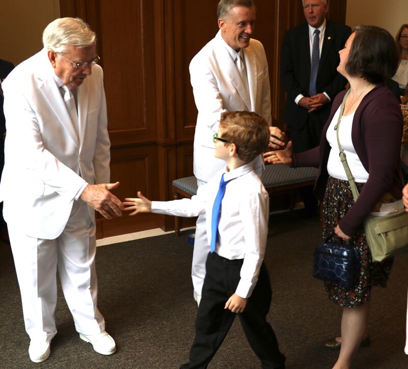 Presidente M. Russell Ballard despide a un jovencito después de la rededicación del Templo de Raleigh, Carolina del Norte el 13 de octubre de 2019. Élder Kevin R. Duncan, a la derecha, estrecha la mano de otra participante del templo.