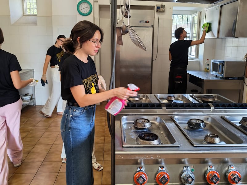 Adultos jóvenes solteros de Sicilia y Malta limpian la cocina en Casa Scalabrini 634 durante un proyecto de servicio en Roma, Italia.