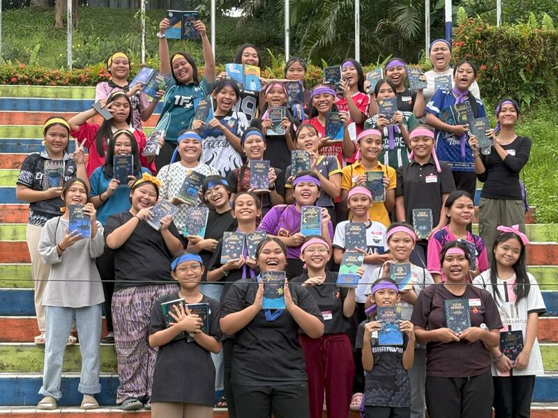 Las mujeres jóvenes posan para una foto con ejemplares del Libro de Mormón que decoraron durante el campamento de Mujeres Jóvenes del Distrito de Sibu, realizado los días 6 y 7 de junio de 2025 en Malasia Oriental.