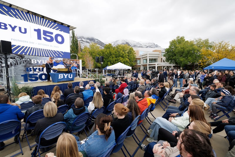 Estudiantes, ex alumnos, administradores y otros se reúnen para abrir una cápsula del tiempo de 50 años durante un evento del Día del Fundador el 16 de octubre de 2025, en el campus de la Universidad Brigham Young en Provo, Utah.