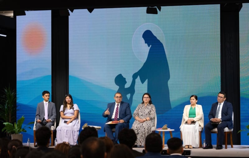 El élder Taylor G. Godoy, Setenta Autoridad General, tercero desde la izquierda, enseña a los jóvenes y sus padres y líderes durante un devocional en Lima, Perú, el 11 de enero de 2026. También estuvieron presentes su esposa, la hermana Carol Godoy, cuarta desde la izquierda; el élder Oswaldo Soto, Setenta de Área, a la derecha; y su esposa, la hermana Dania Soto, segunda a la derecha.