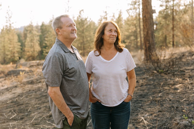 De pie entre las cenizas, cerca de su hogar, Todd y Debbie Rogers relatan la historia de cómo su casa sobrevivió a los incendios forestales de Spokane en Spokane, Washington, el sábado 22 de agosto de 2026.