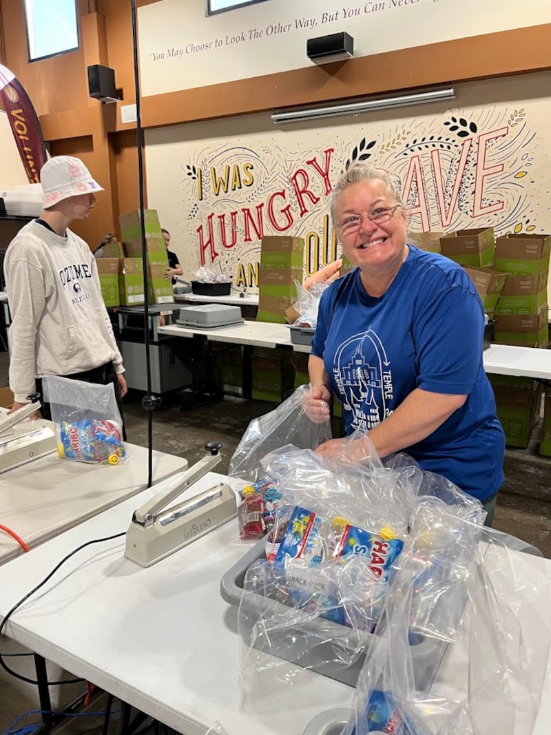 Una amiga de Gwynne Fullmer empaca bolsas de refrigerios en el Midwest Food Bank en Gilbert, Arizona, el 18 de octubre de 2025, para celebrar el cumpleaños número 70 de Fullmer.