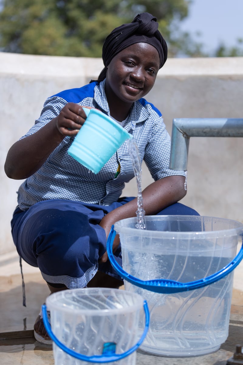 Bibata Fofana, recoge agua en el grifo recién instalado en la escuela Soubouy en Burkina Faso en noviembre de 2024.