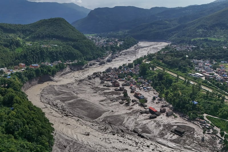 Casas dañadas están precariamente cerca de las orillas hinchadas y llenas de escombros del río Trishuli después de inundaciones repentinas en el distrito de Nuwakot de Nepal el miércoles, 26 de agosto de 2026.