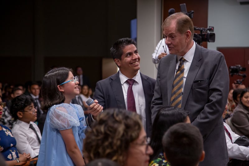 El élder Gary E. Stevenson, del Cuórum de los Doce Apóstoles, interactúa con un joven durante un devocional.