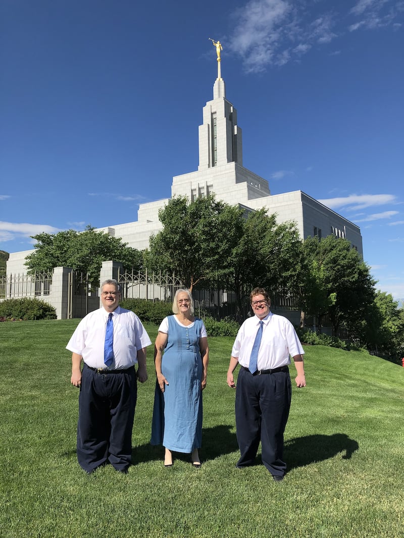 De pie frente al Templo de Draper, Utah, Daniel Sorensen, Kris Sorensen y Matthew Sorensen posan para una fotografía juntos después de su servicio en el templo el 26 de junio de 2021.