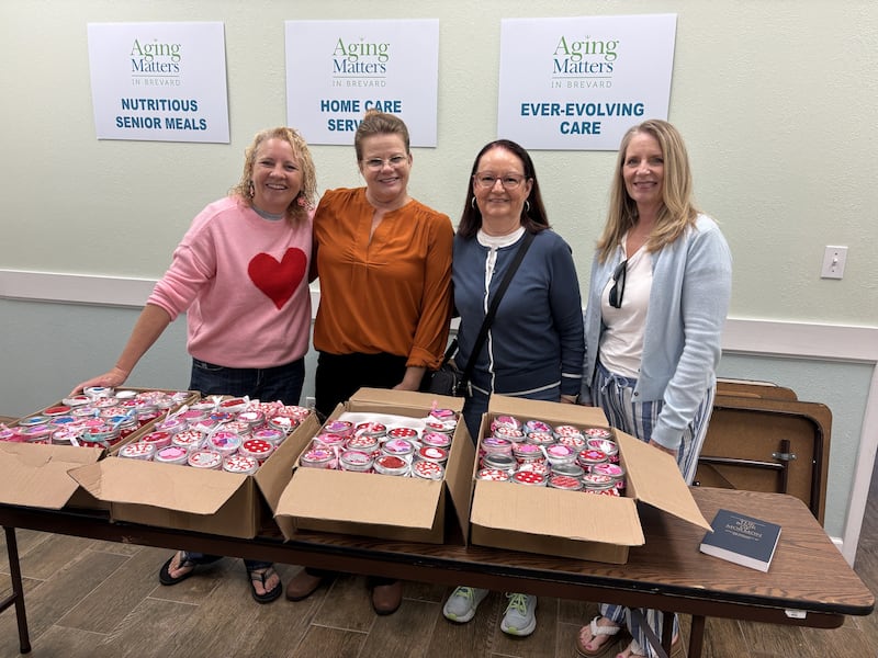 Cuatro mujeres de la Estaca Cocoa Florida y de Aging Matters muestran los frascos de alegría del Día de San Valentín hechos durante una actividad de la Sociedad de Socorro de la estaca en febrero de 2026.