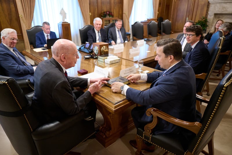 El presidente Henry B. Eyring, primer consejero de la Primera Presidencia, entrega un ejemplar de tapa dura del Libro de Mormón a Miloslav Stašek, embajador de la República Checa ante los Estados Unidos, durante una visita en el Edificio de Administración de la Iglesia en Salt Lake City, el martes 28 de abril de 2026.
