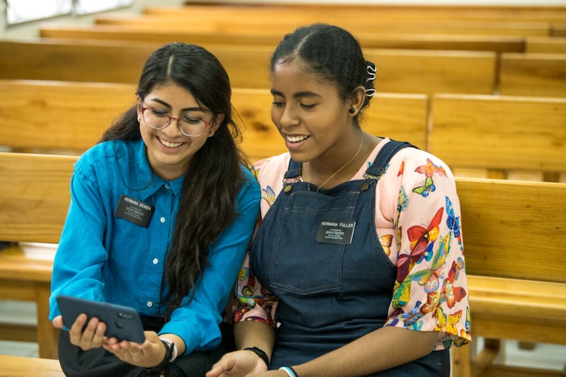 La hermana Angie Granda, izquierda, y la hermana Andrea Fuller, de la Misión Ecuador Quito, imparten una lección en línea en Baños, Ecuador, en octubre del 2020. La Misión Ecuador Quito recibió teléfonos inteligentes en mayo.