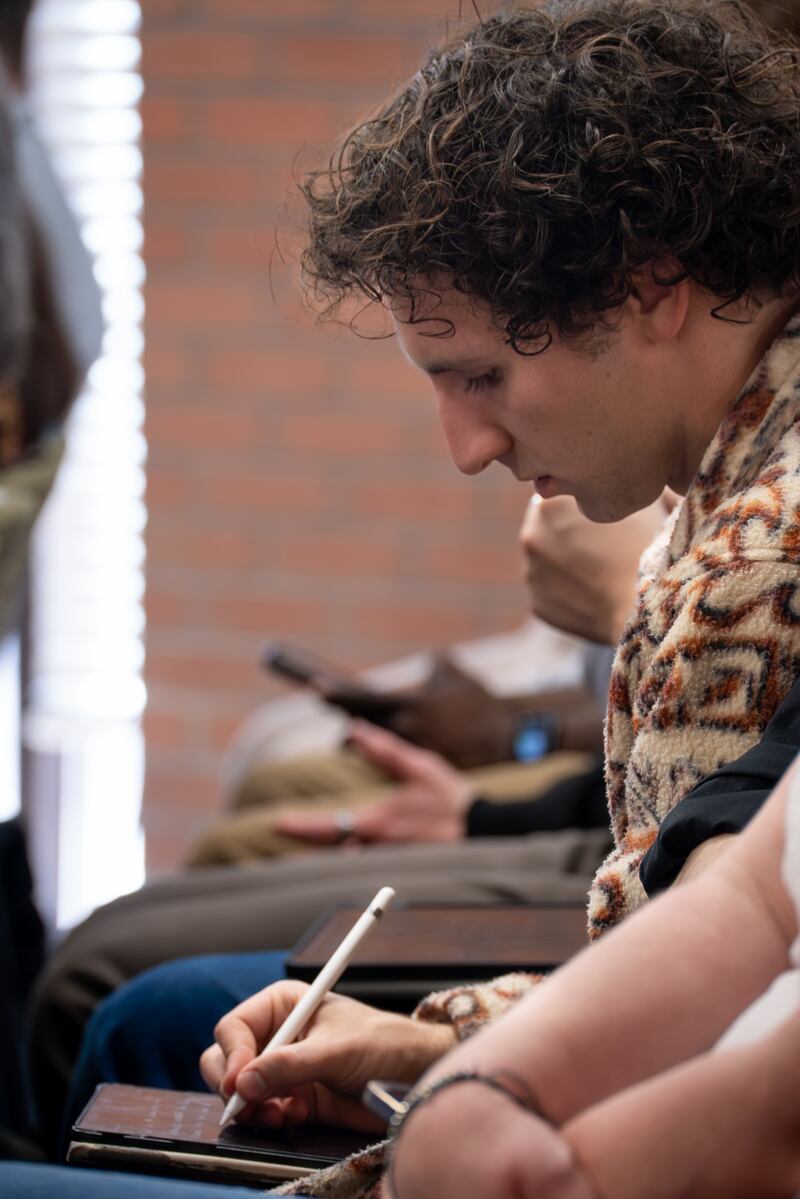 Un joven toma notas mientras el élder K. Brett Nattress, Autoridad General de los Setenta, ofrece un devocional en Ensign College el martes, 24 de marzo de 2026.