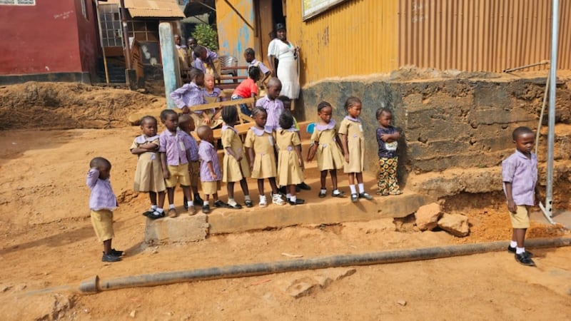 Niños escolares observan durante la donación de un pozo de agua en New England Ville, en el occidente de Freetown, Sierra Leona, el 3 de abril de 2026.