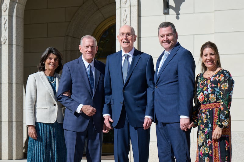 El presidente Henry B. Eyring está de pie frente al Templo de Idaho Montpelier entre los Setentas Autoridades Generales élder Steven R. Bangerter, izquierda, y élder Ricardo P. Giménez, derecha, y sus esposas, la hermana Susan A. Bangerter y la hermana Catherine Giménez, respectivamente.