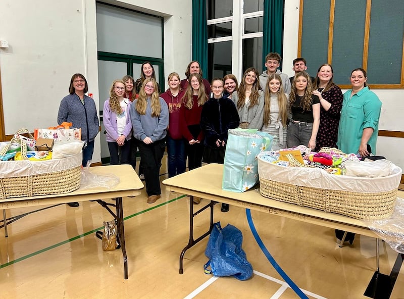 Jóvenes de la Estaca Northampton Inglaterra se toman una foto con algunas de las canastas que armaron con artículos para bebés para entregar a nuevas madres durante una actividad de servicio en octubre de 2024.