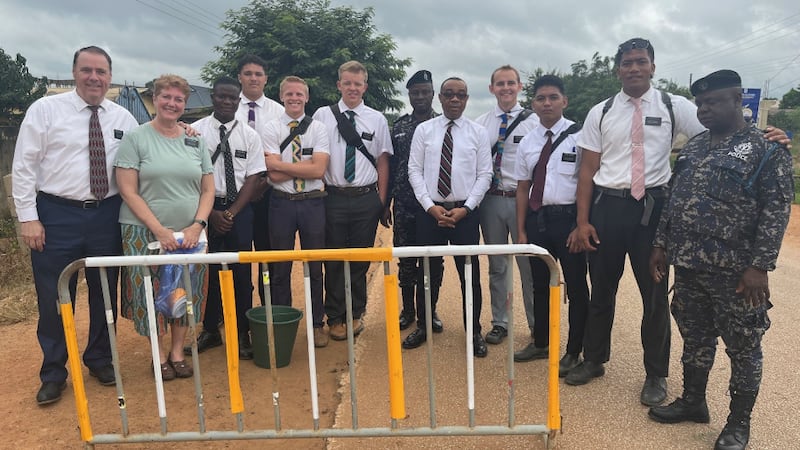 Los misioneros, líderes y agentes de policía colocan cinta reflectante en las barreras de seguridad durante el Proyecto de Servicio de Toda África el 17 de agosto de 2024.