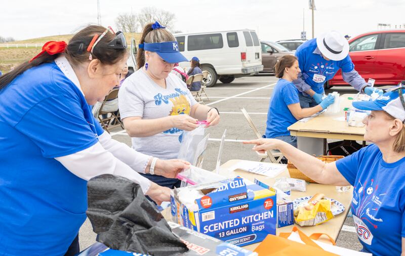 Personas participan en un proyecto de servicio antes de la noche de JustServe en el juego de los Kansas City Royals en Kansas City, Misuri, el jueves 9 de abril de 2026.