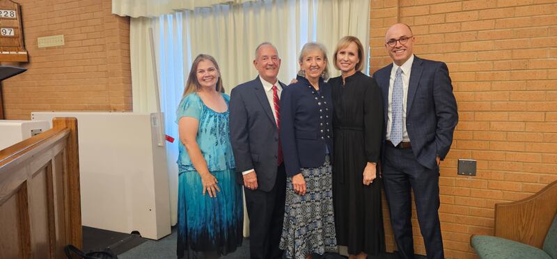 El élder Kirt L. Hodges, un Setenta de Área de La Iglesia de Jesucristo de los Santos de los Últimos Días, y su esposa, la hermana Shawna Hodges, a la izquierda, y la hermana Amy A. Wright, primera consejera de la presidencia general de la Primaria, y su esposo, el hermano James Wright, a la derecha, posan para una foto con un asistente tras un devocional en Nauvoo, Illinois, el 18 de septiembre de 2025.