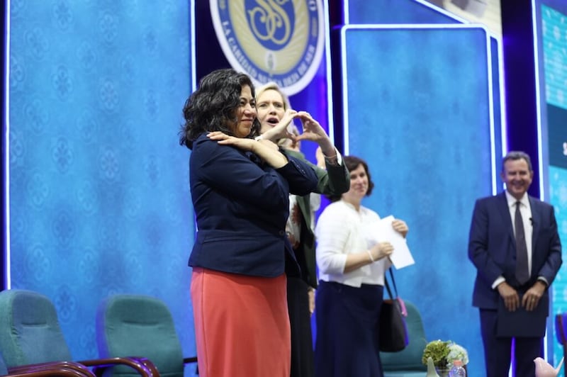 La hermana Reyna I. Aburto y la presidenta Bonnie H. Cordon comparten señales de amor con las hermanas de la Sociedad de Socorro después de un devocional el 3 de junio de 2022.