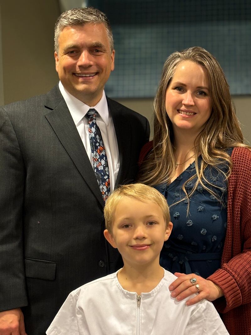 Traci Law — compositora de "Pequeño Niño en un Pesebre" — y su esposo, Ryan, sonríen con su hijo Joshua el día de su bautismo en Spanish Fork, Utah, noviembre de 2024.