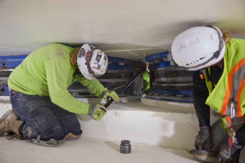 Los trabajadores retiran pernos de una de las placas de un aislador de base ubicado a 20 pies debajo del Templo de Salt Lake en Salt Lake City el jueves, 25 de junio de 2026.