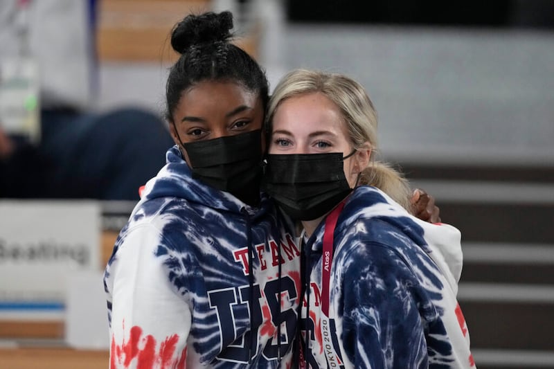 Simone Biles, de Estados Unidos, posa con su compañera de equipo Mykayla Skinner mientras ven la final masculina de gimnasia artística en los Juegos Olímpicos de Verano 2020, el miércoles, 28 de julio de 2021 en Tokio.