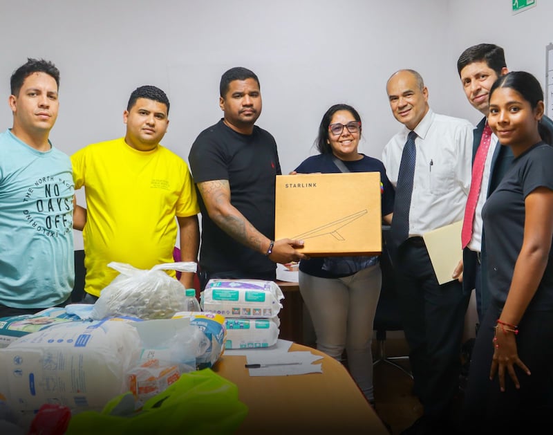 Miembros de La Iglesia de Jesucristo de los Santos de los Últimos Días posan para una foto mientras entregan equipo de comunicación de emergencia a funcionarios del gobierno el 2 de julio de 2026 en La Guaira, Venezuela.