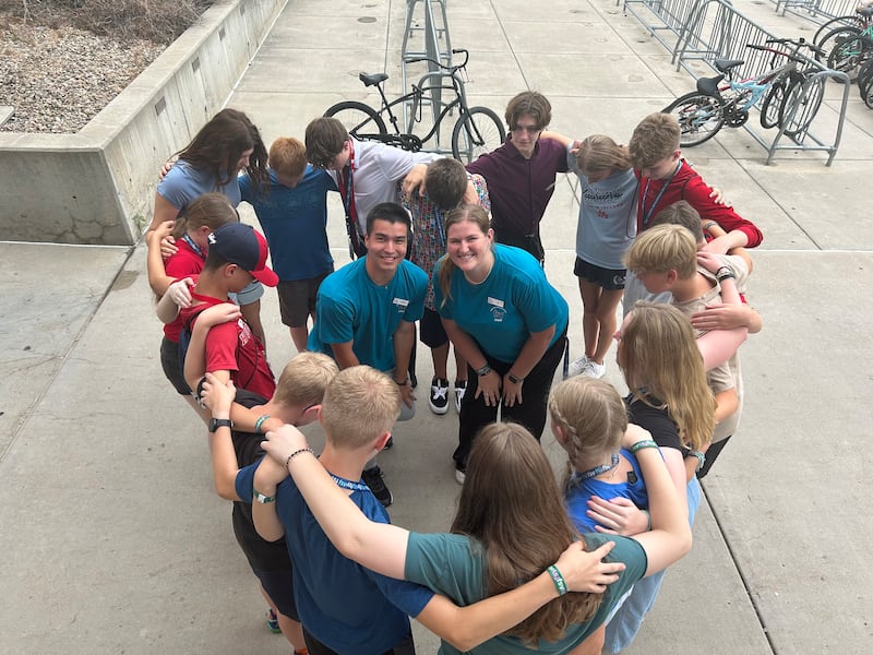 Beldon Clark, a la izquierda, se toma una foto con otros empleados y jóvenes formando un corazón en una sesión de Para la Fortaleza de la Juventud en 2025.