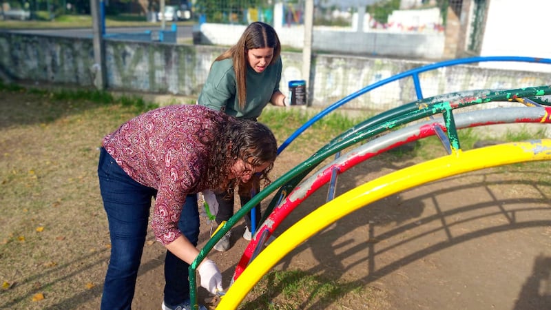 Miembros de la Sociedad de Socorro de la Estaca Montevideo Norte pintan el equipo del patio de recreo en una escuela local en Montevideo, Uruguay, el 9 de abril de 2022.
