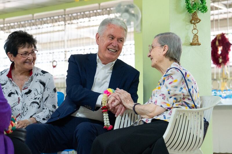 El élder Dieter F. Uchtdorf, en el centro, y la hermana Harriet Uchtdorf, a la izquierda, conversan con la hermana Louise Horgan en las Hermanas del Buen Pastor Bangkok.