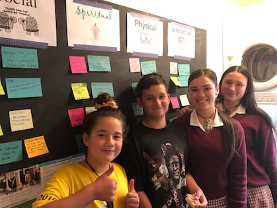 Los hijos de una familia de Christchurch, Nueva Zelanda, posan para una fotografía frente a su pizarra de planificación del programa para niños y jóvenes, que se encuentra en el cuarto de lavado de su hogar. Los niños estaban entusiasmados por mostrarle a la hermana Becky Craven cómo habían implementado el nuevo programa de inmediato luego de los anuncios que se hicieron en la conferencia general de octubre de 2019. La hermana Craven visitó Christchurch durante un viaje al Área Pacífico con la …