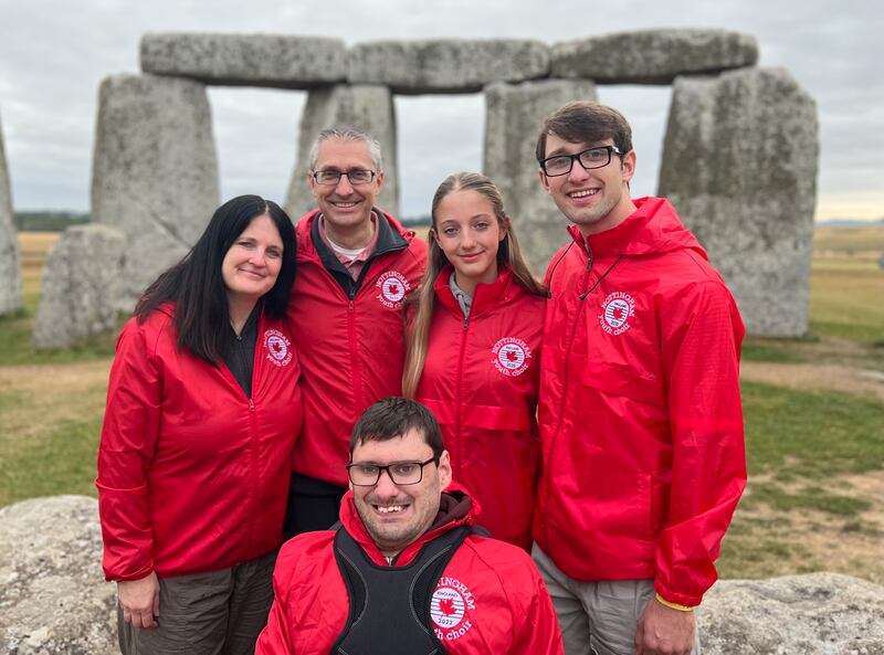 El élder Nathan Smith, al frente en el centro, sonríe con su familia frente al monumento de Stonehenge en Inglaterra el 9 de agosto de 2025.