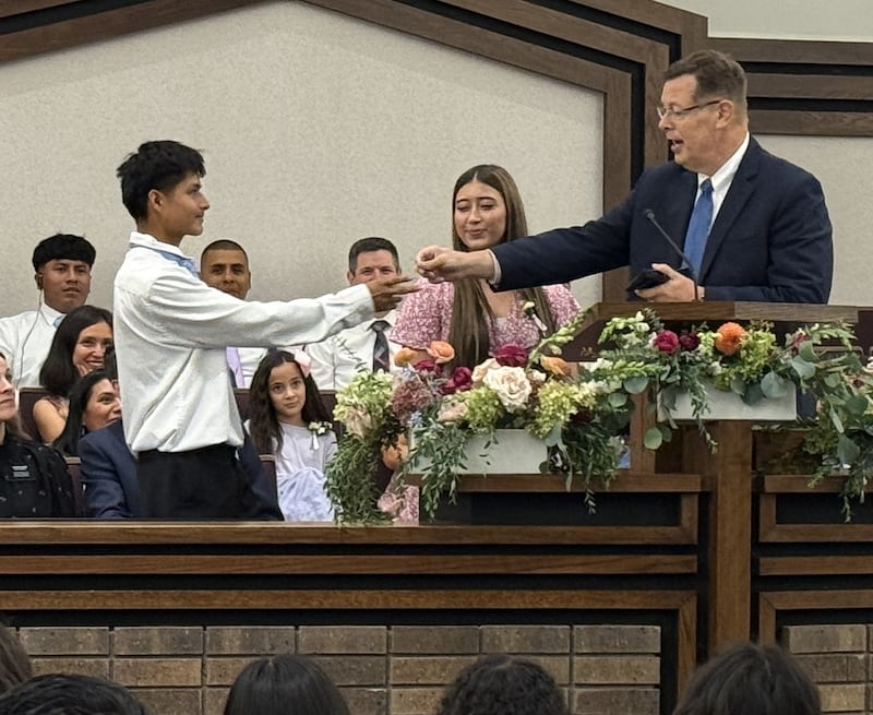El élder Clark G. Gilbert del Cuórum de los Doce Apóstoles le entrega a Jose Coy, de 18 años, una tarjeta con su correo electrónico en el Centro de Estaca de Schaumburg Illinois en Chicago, Illinois el domingo 20 de septiembre de 2026.