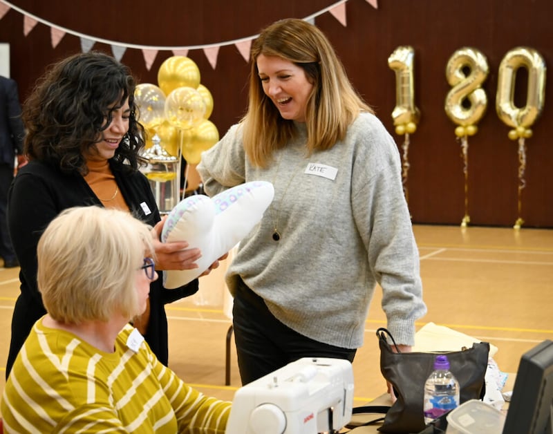 La hermana Reyna I. Aburto, segunda consejera de la presidencia general de la Sociedad de Socorro, admira una almohada de un proyecto de servicio en Huddersfield, Reino Unido, en marzo de 2022. El aniversario 180º de la Sociedad de Socorro fue el 17 de marzo de 2022.