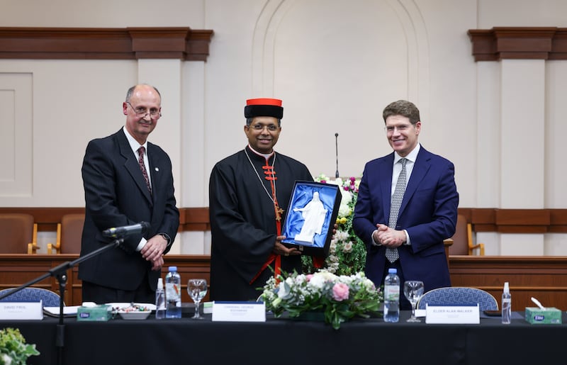 El Cardenal George Jacob Koovakad, prefecto de la Dicasterio para el Diálogo Interreligioso, en el centro, sostiene una estatua en miniatura del Cristo con el élder Alan R. Walker, una Setenta Autoridad General y presidente del Área Sur de América del Sur de la Iglesia, de pie a la derecha en un evento interreligioso en Buenos Aires, Argentina, el 10 de septiembre de 2026.
